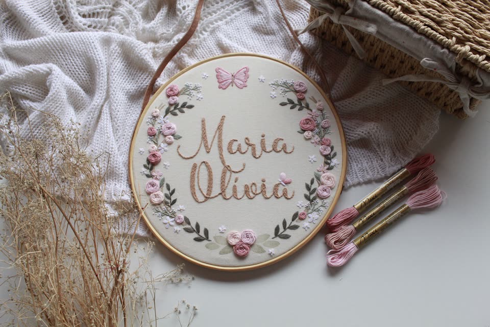 Porta-maternidade em bastidor com o nome Maria Olívia, guirlanda de rosas e borboleta