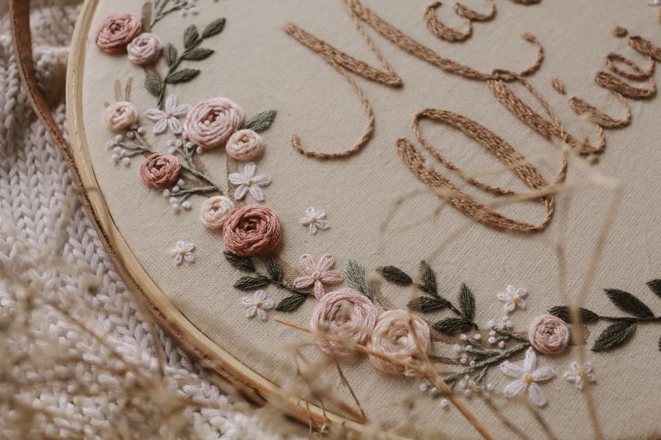 Detalhe do bordado de rosas em relevo e do nome Maria Olívia em linha dourada